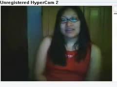 A gorgeous Asian girl is acting sensuously on camera.
